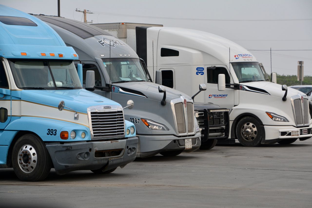 services-03 A row of parked semi trucks in Eagle Pass, Texas, showcasing various models and colors.